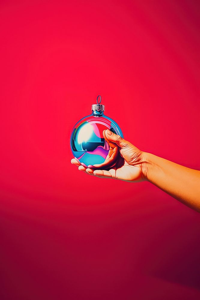 A hand holding a small christmas ornament sphere celebration photography. AI generated Image by rawpixel.