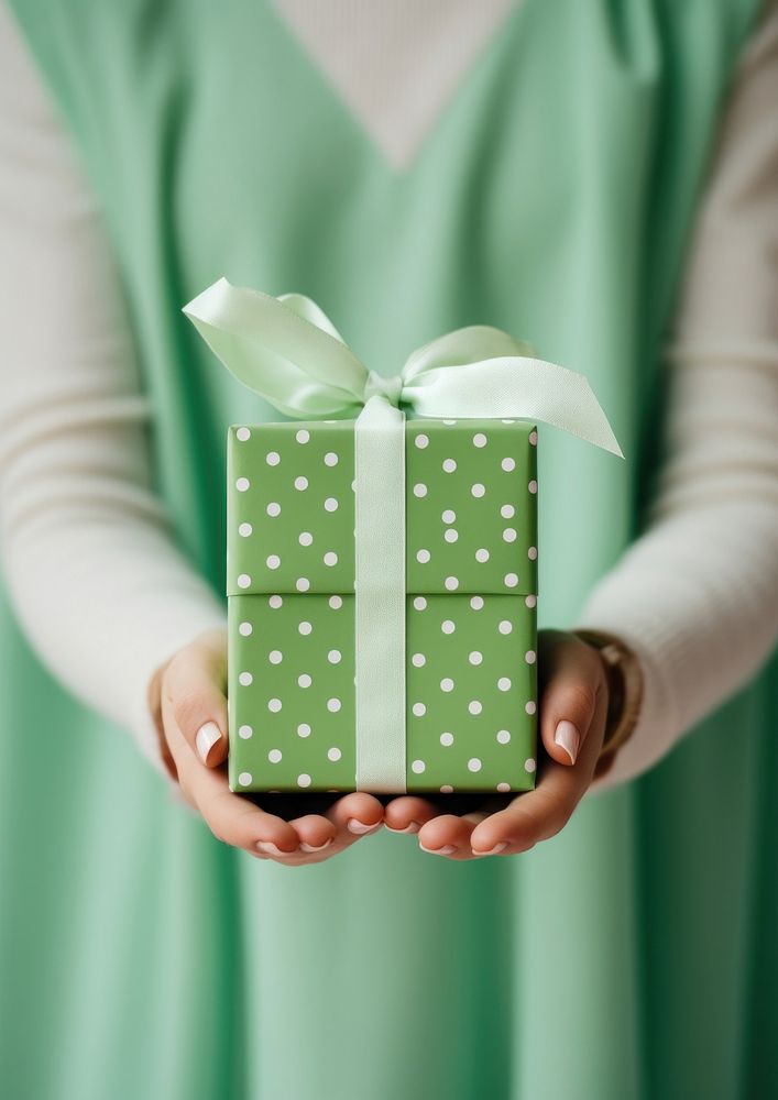 Polkadot gift box holding green hand. AI generated Image by rawpixel.