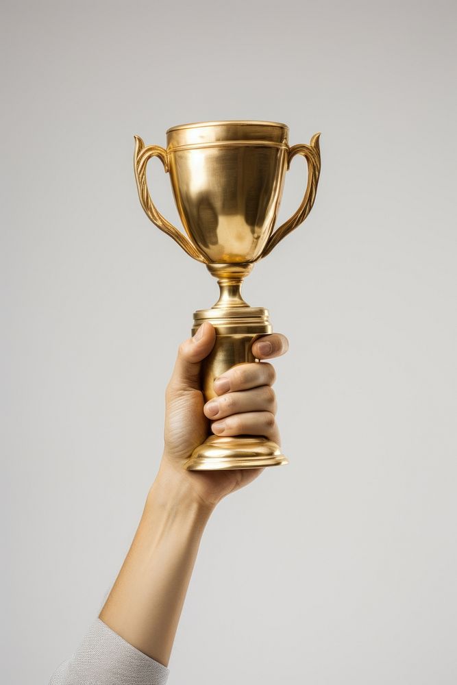 Hand rising up a gold trophy achievement refreshment drinkware. AI generated Image by rawpixel.