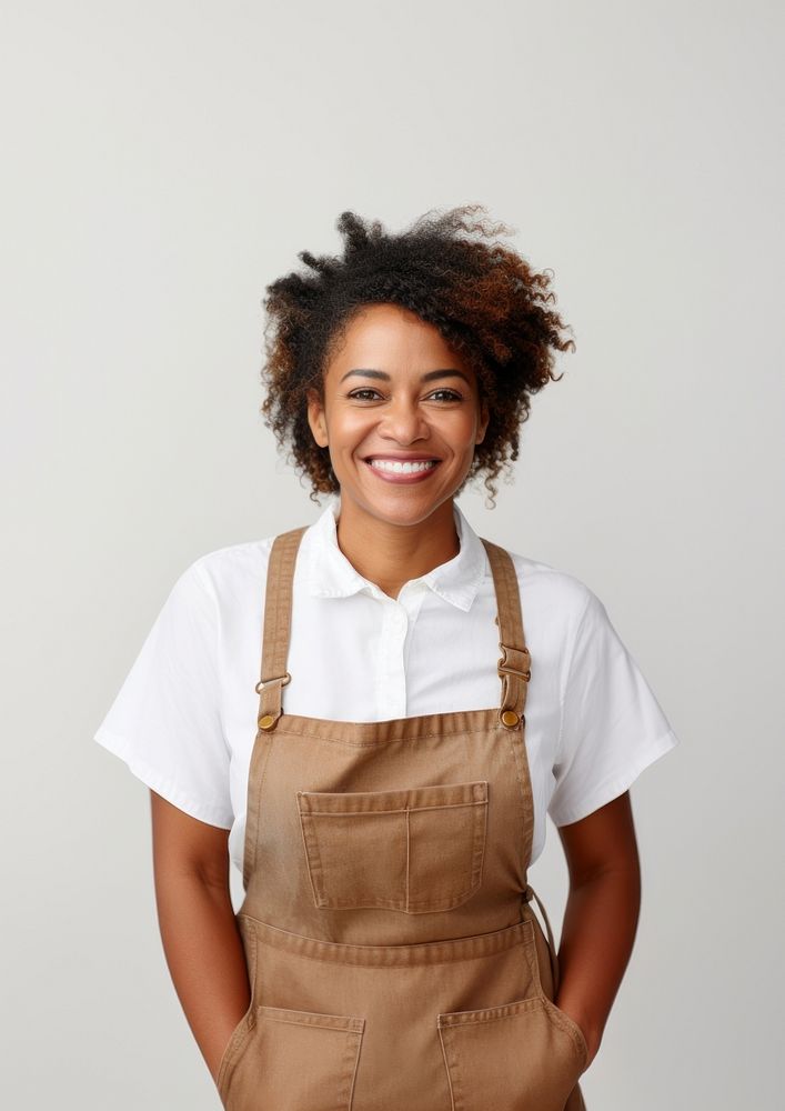 A multiracial woman wearing white linen shirt with a brown apron smiling smile white background. AI generated Image by…