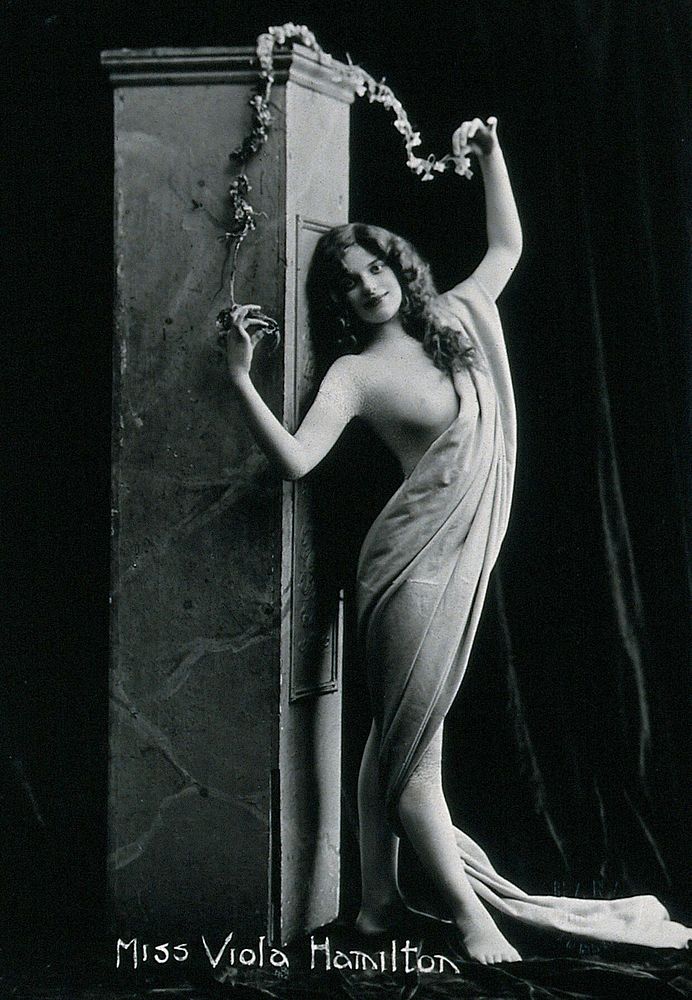 Viola Hamilton, posing in a classical attitude against a square column.