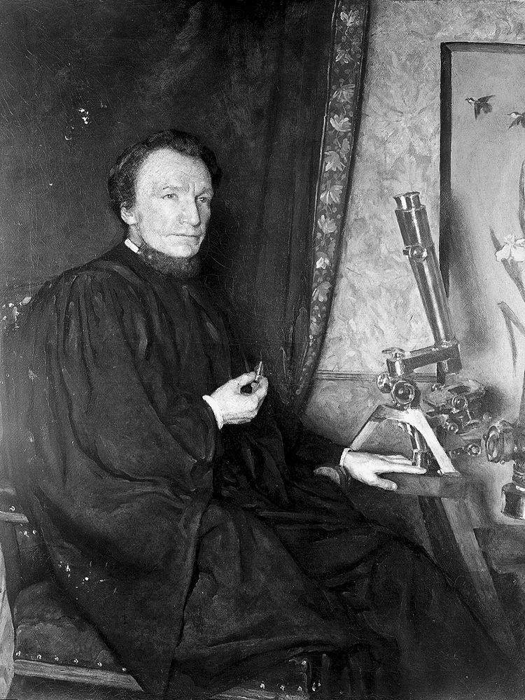 Portrait of W. H. Dallinger, seated at r. to microscope, after restoration