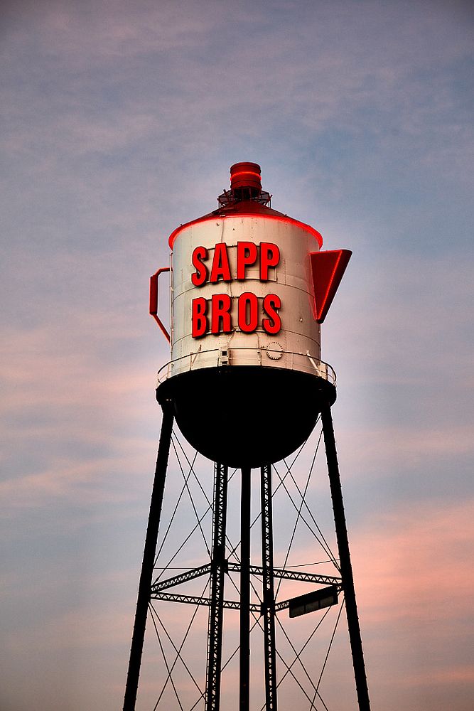                         Dusk is approaching and the illumination of the neon lettering on this signature coffee-pot-shaped…