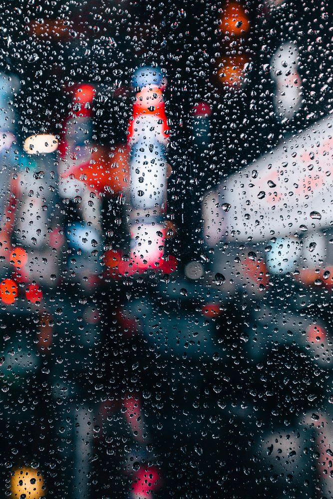 The lights of the urban center of a city viewed through a rain-dappled window, free public domain CC0 photo.