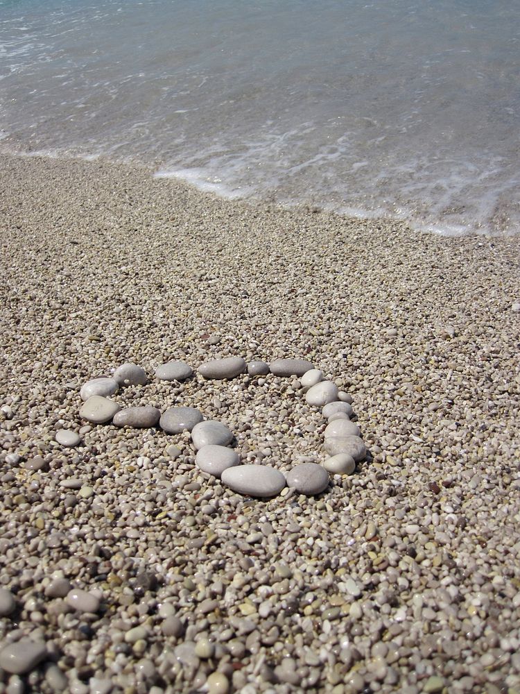 Heart shape pebbles on sand. Free public domain CC0 photo.