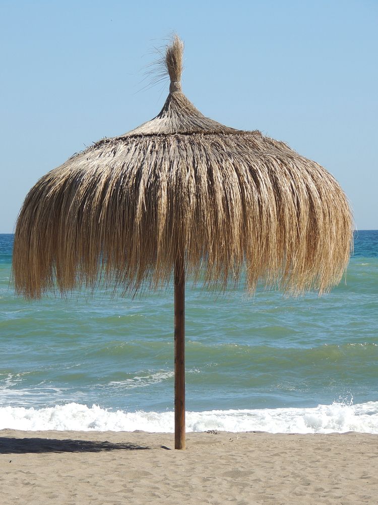 Beach umbrella made from hay. Free public domain CC0 photo.