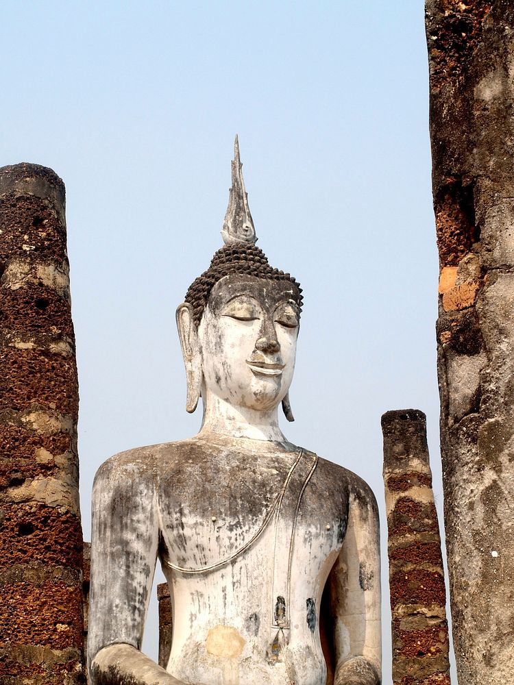 Free ancient Buddha statue between brick tiles public domain CC0 photo.