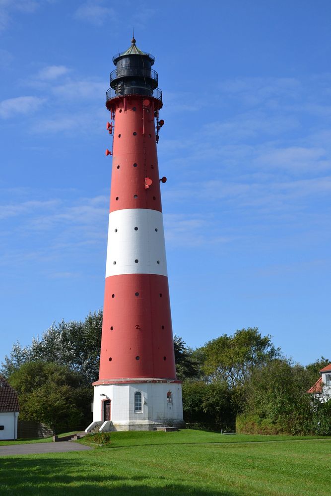 Red and white lighthouse on open field. Free public domain CC0 photo.
