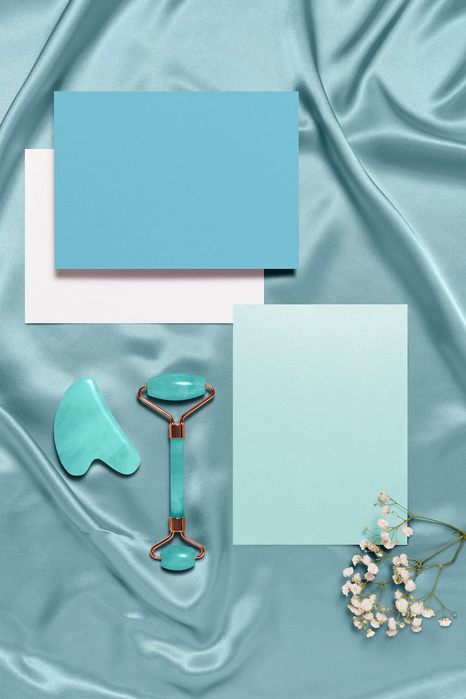 Blank blue paper with jade roller and gua sha, flay lay
