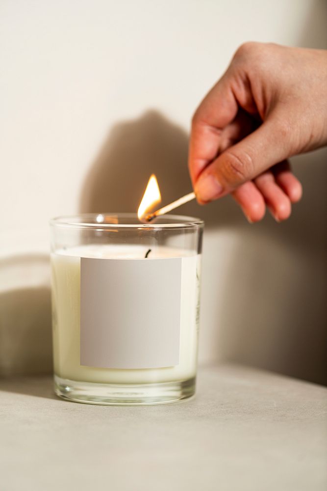 Woman lights scented candle, home aroma