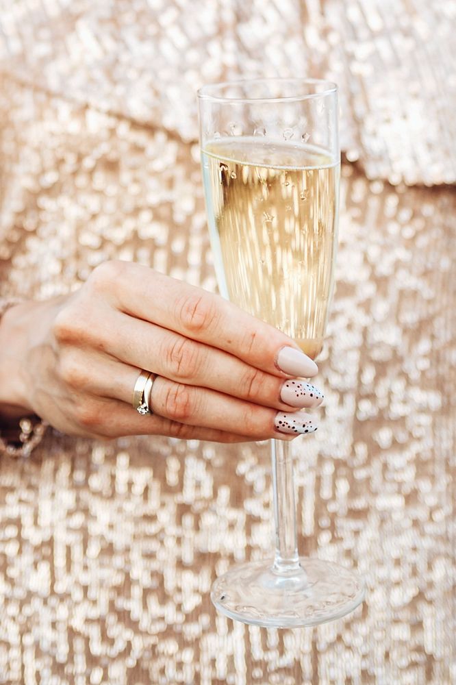 Closeup of a woman in a gold dress having a glass of champagne