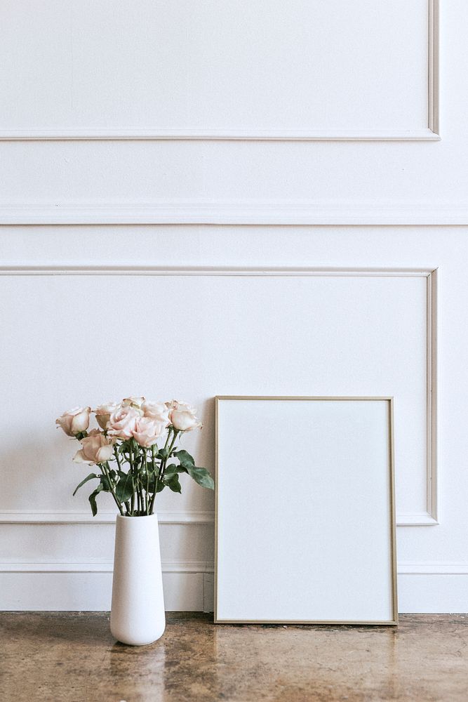 Frame against a white wall by a vase of flowers