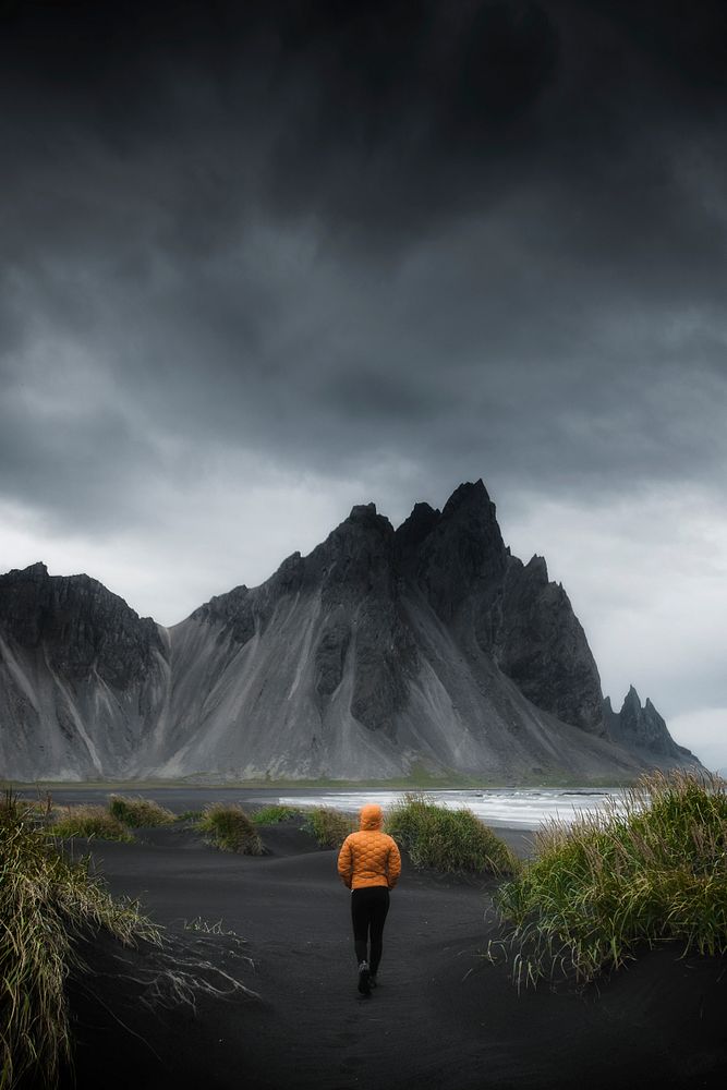 Man walking on a black sand beach, Iceland