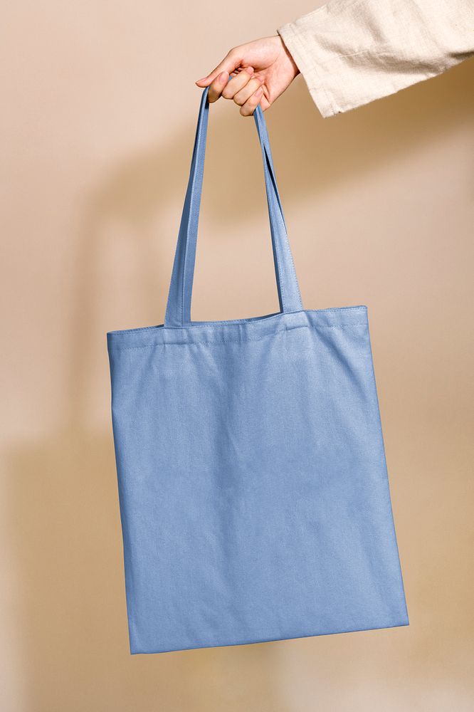 Woman holding a blue tote bag in her hand
