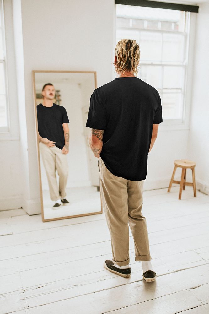 Men&rsquo;s black tee mockup psd and beige pants in front of a mirror