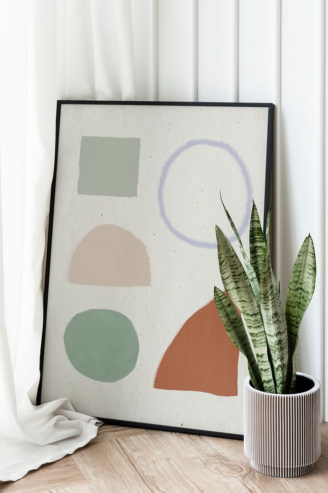 Snake plant in a gray plant pot by a picture frame mockup on the floor