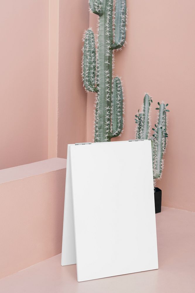 White poster on a pastel pink floor by cacti
