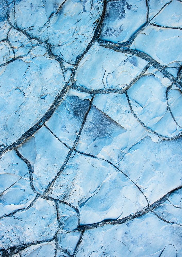 Cracked ground texture, blue background 
