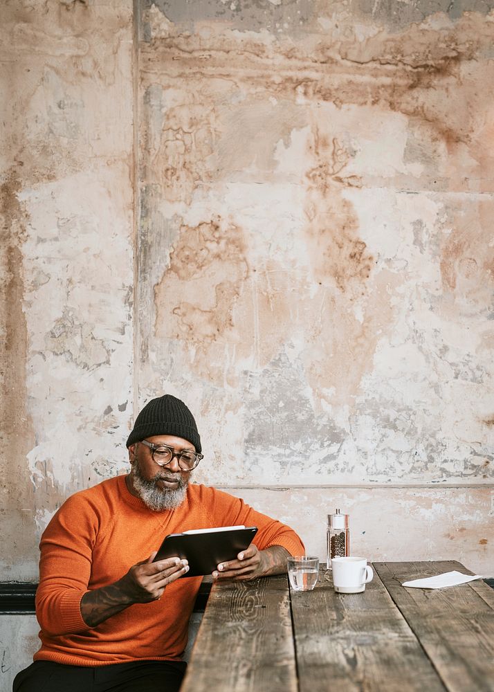 Senior man using tablet at coffee shop