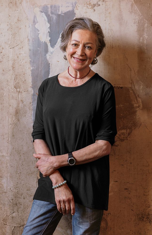 Relaxed woman standing against patina wall