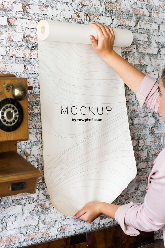 Woman rolling out a paper mockup