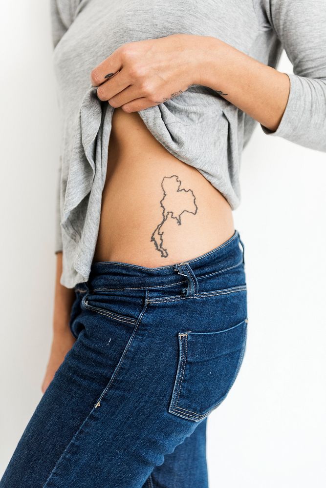 Woman is showing Thailand map tattoo on her waist