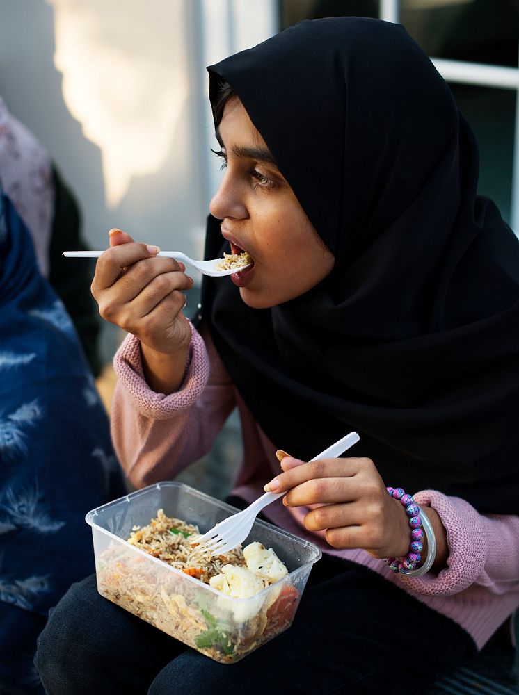 Young Muslim student eating lunch during lunch time