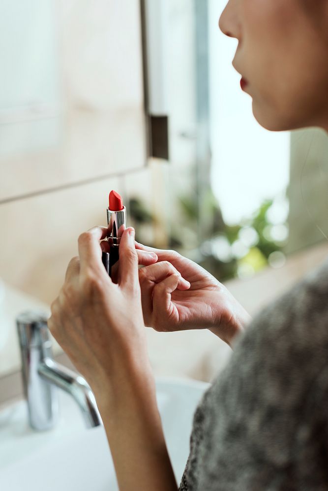 Close up of a woman applying lipstick