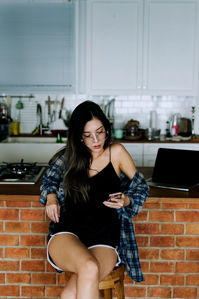 Girl on her phone by the kitchen bench
