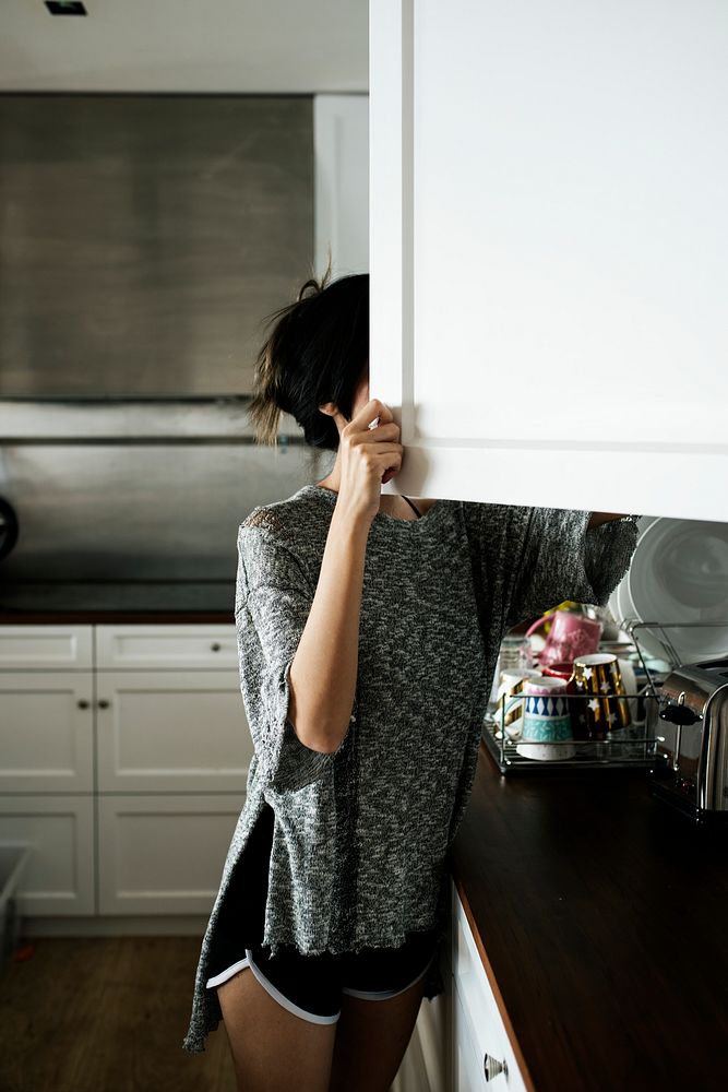 Woman checking the kitchen cupboard