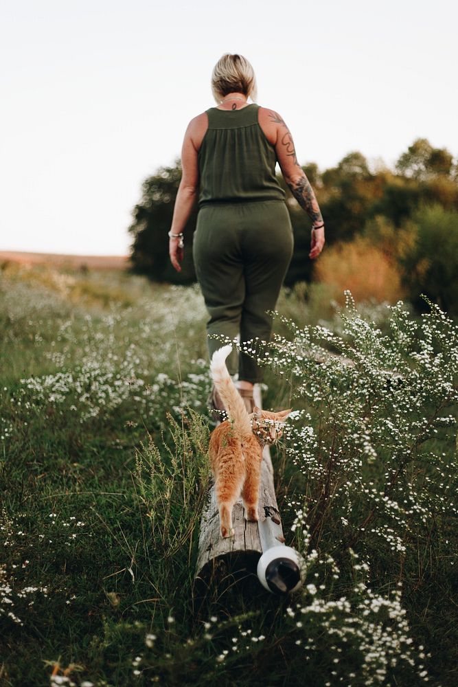 A cat following it's owner in a farm