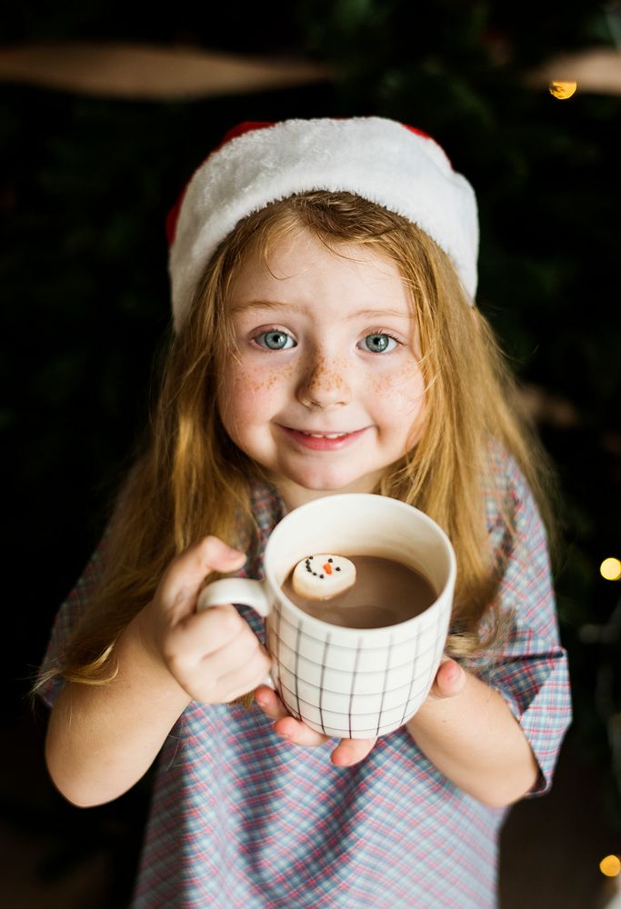 Little girl enjoying a mug of hot chocolate