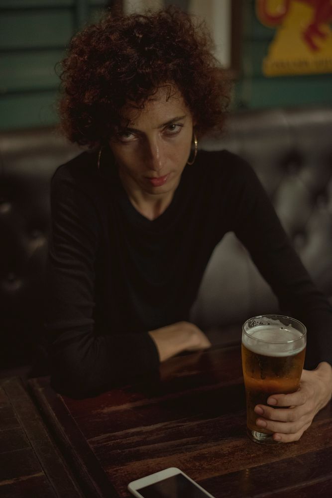 Woman having a beer at a bar