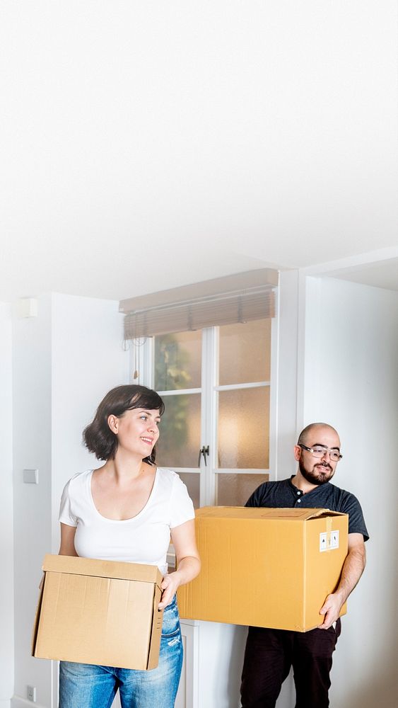 Happy couple moving in together and carrying boxes text space
