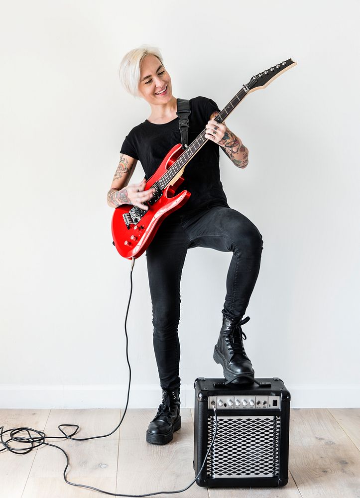 Tattooed woman playing electric guitar