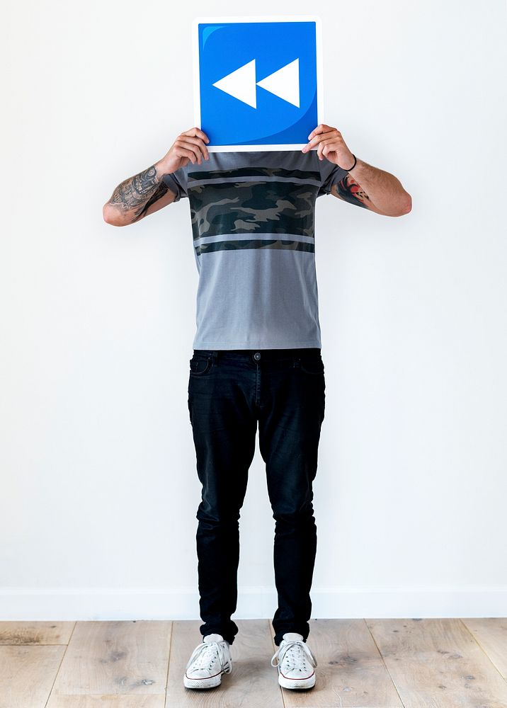 Man with tattoo holding backward icon