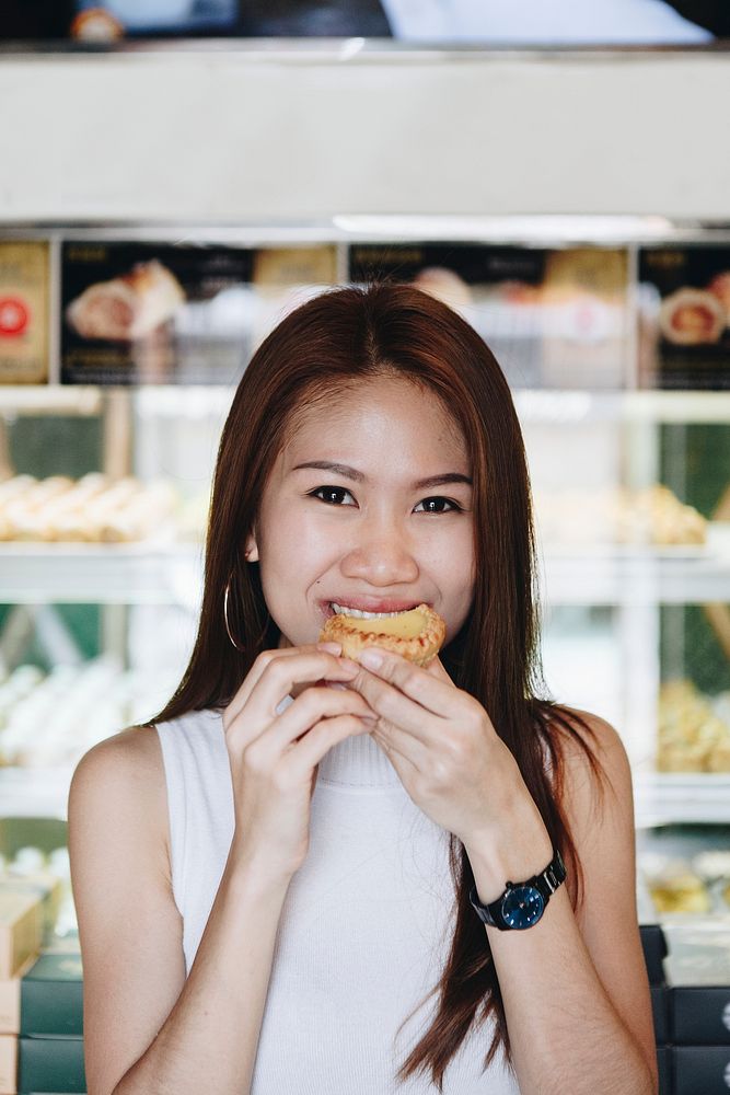 Asian girl having a bite of tart