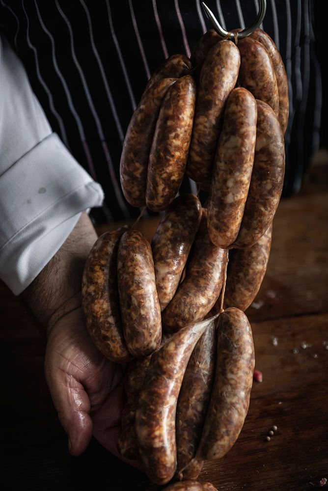 Butcher with smoked sausages on a string
