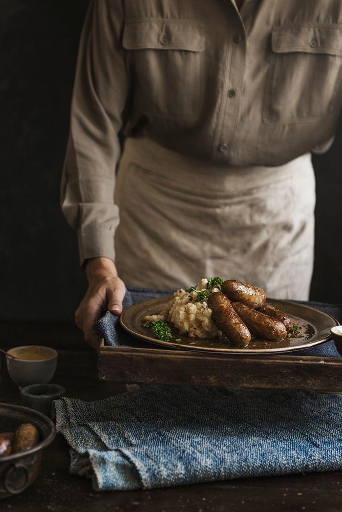 Woman serving bangers and mash