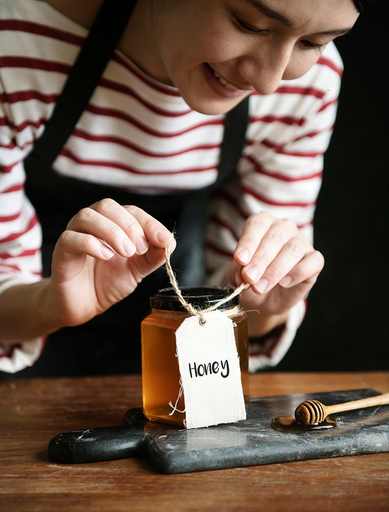 Woman packing organic honey into a jar