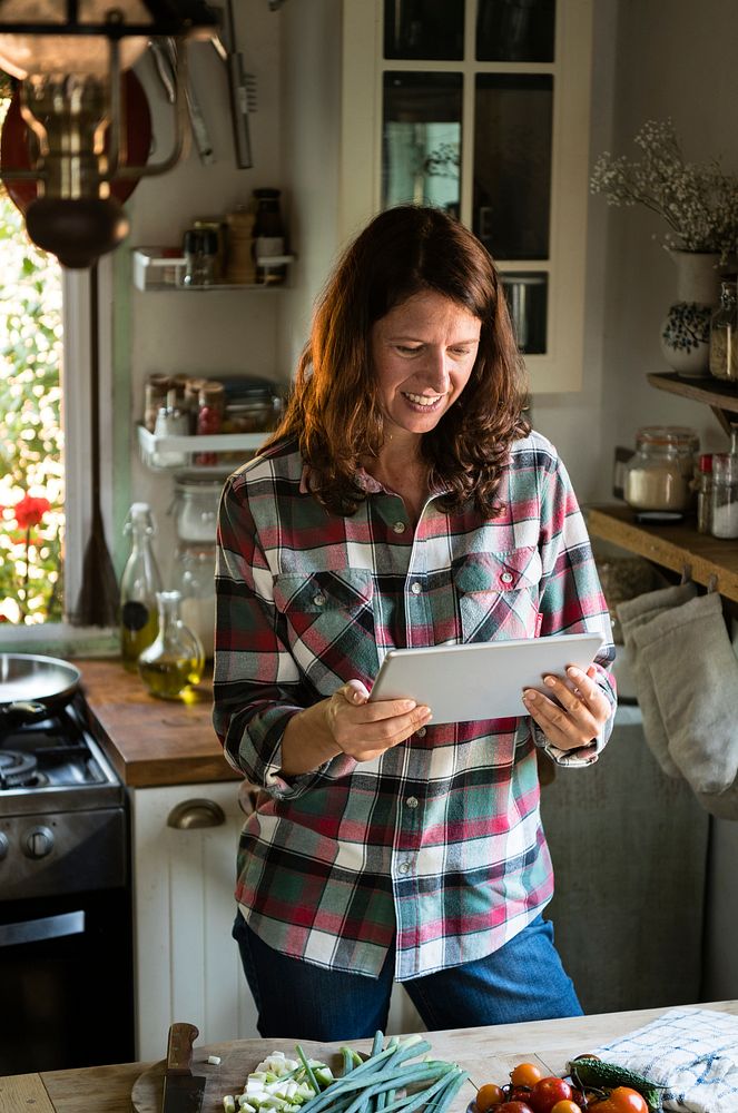 Happy woman reading a recipe from a tablet
