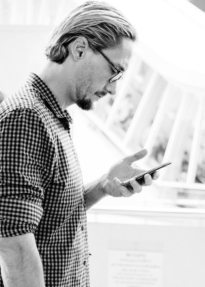 Blond man texting on his phone