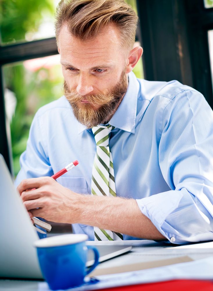 Bearded businessman taking notes