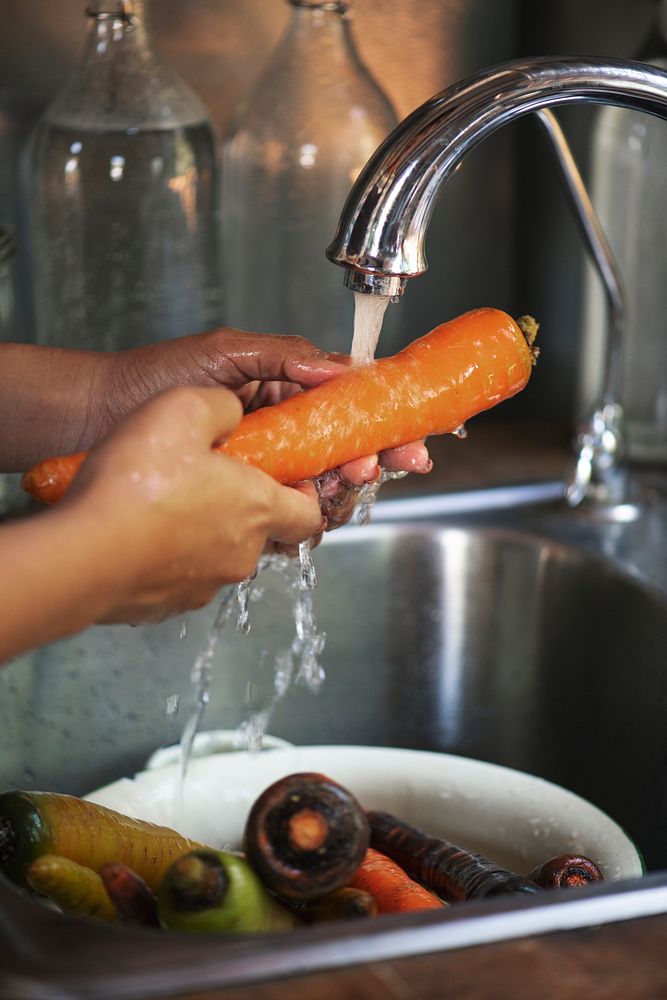 Chef washing a carrot in the sink
