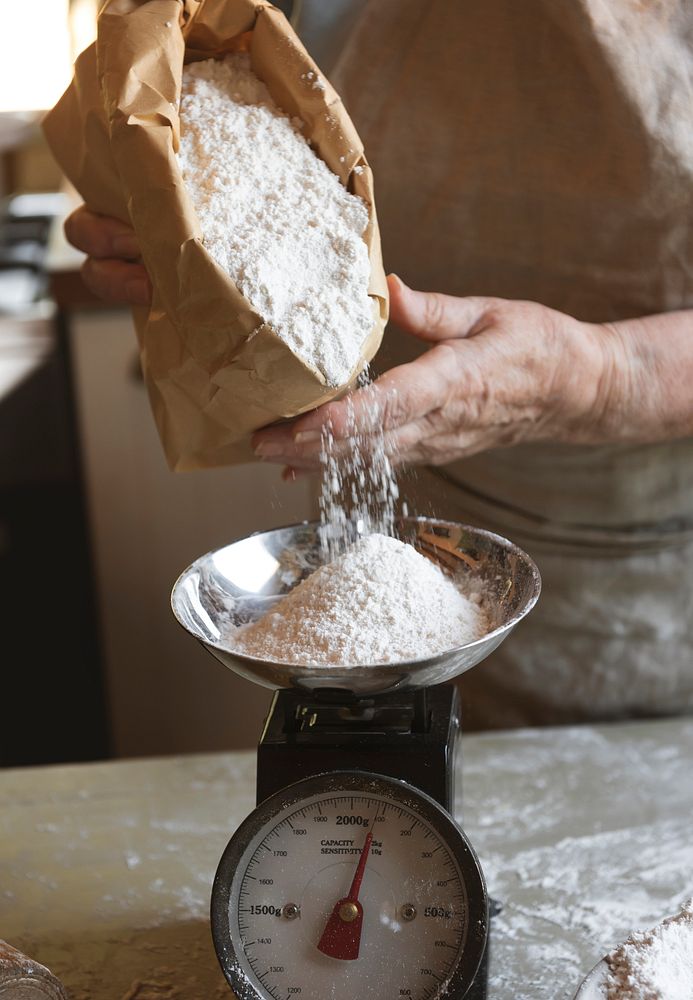 Baker weighing flour on a scale