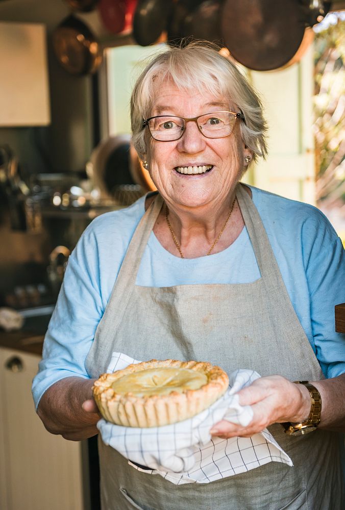 A grandmother carrying homemade fruit pie food photography recipe idea