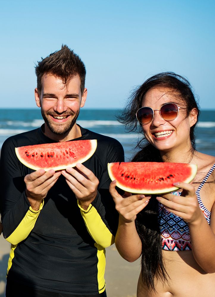 Couple eating watermelon on summer beach