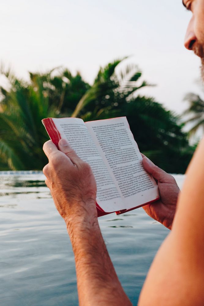 Man reading a book in the swimming pool