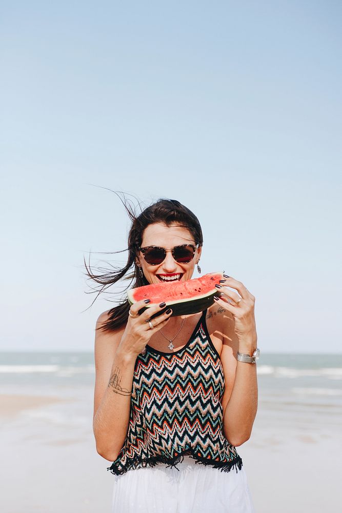 Woman eating watermelon at the beach