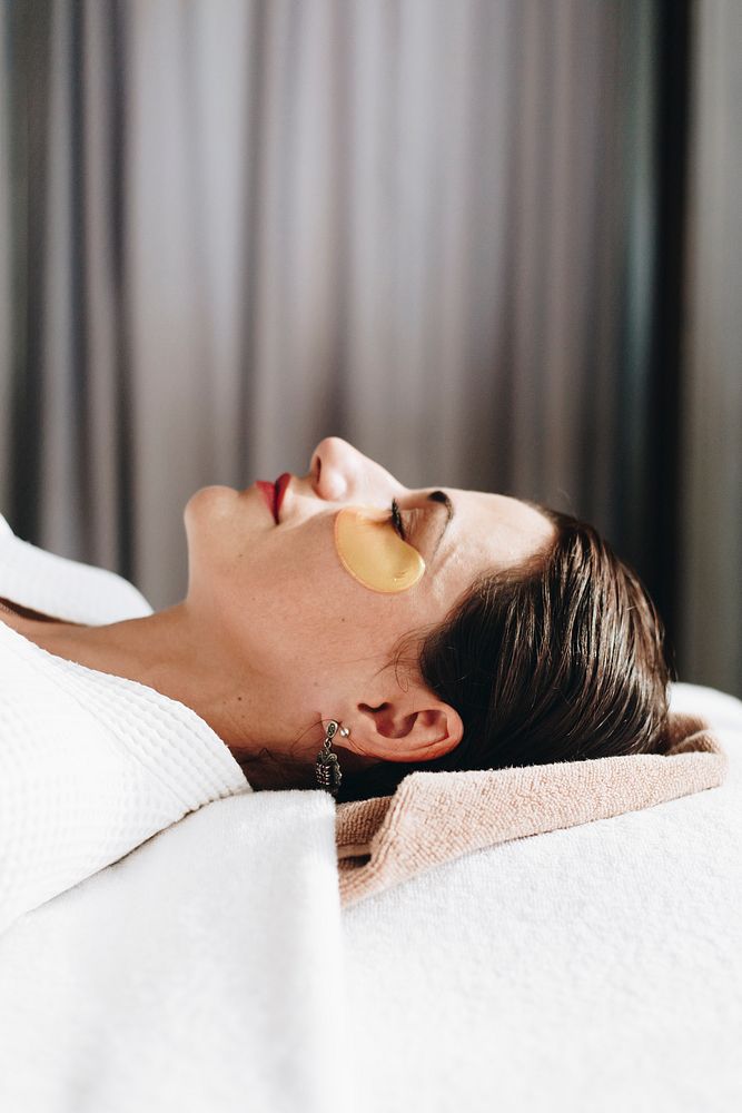 Woman relaxing with a golden eye mask treatment